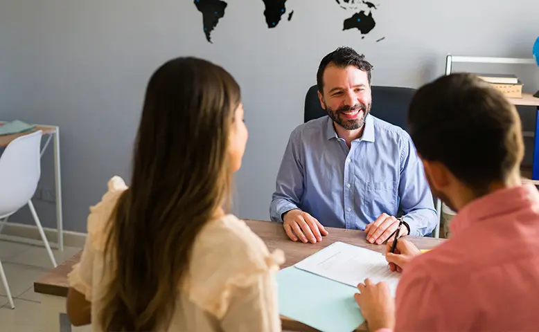 Couple Consulting With a Travel Agent in an Office